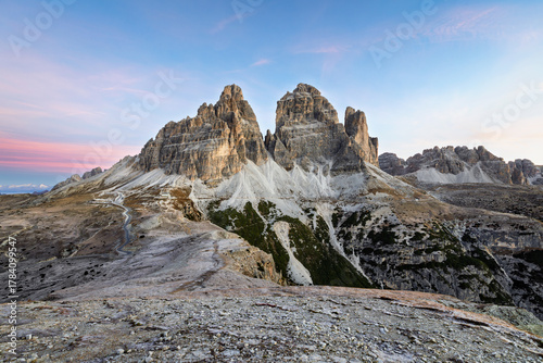 Autumn morning in Tre Cime di Lavaredo National park, Dolomite Alps mountains, Trentino Alto Adige region, Sudtirol, Dolomites, Italy, Europe. Landscape rocky mountains. Sunrise sky with pink horizon