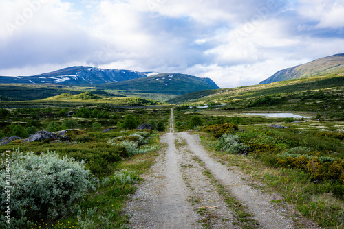 Remote gravel road leading through vast mountain tundra