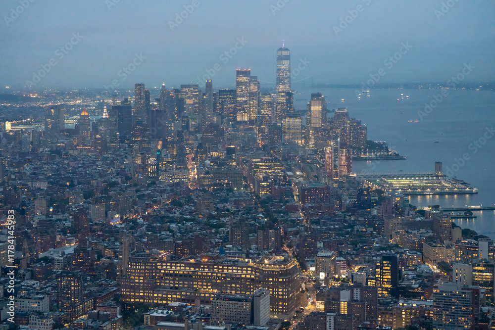 Obraz premium Bird’s-eye nighttime panorama of NYC Manhattan highlighting city lights and urban layout