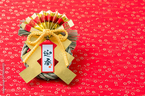 迎春の正月飾り（赤と金の和柄背景）