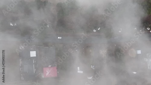 A serene aerial view of a mist-covered forest road in Japan. A single car glides through the fog, creating a tranquil, cinematic scene perfect for relaxation and meditation.