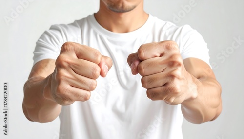 Man clenching fists in front of him, expressing strength and determination
