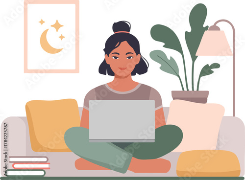 Young woman working from home comfortably on sofa with laptop