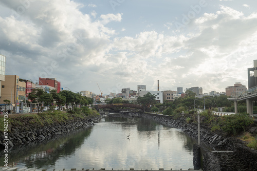 cityscape and cloudy sky reflecting on the river in jeju island