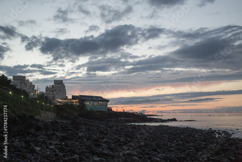 sunset scenery of ocean and city seen from Yongduam Rock in jeju island