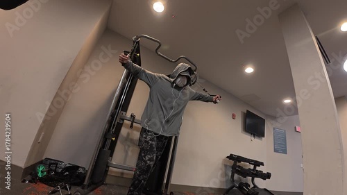 Man performing cable chest fly exercise in a modern gym