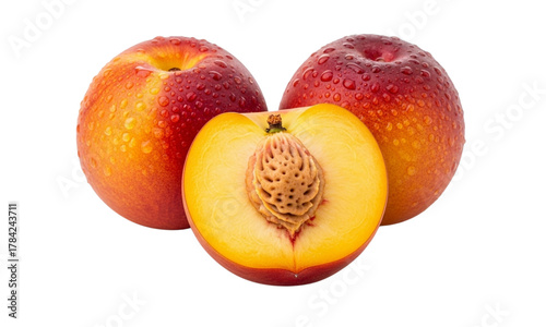 Close-up shot of three ripe peaches, one sliced open to reveal the pit.