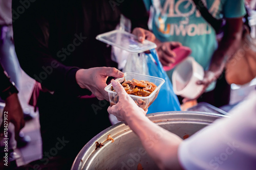 Volunteers are giving food to the homeless poor, Free distribution of food to the poor in today's society