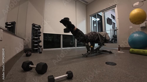 Man Performing Lying Dumbbell Leg Curls for Hamstrings


