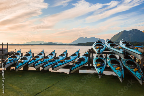 Colorful kayaks on the pier at sunset, Blue kayaks lined up on a wooden dock at sunset. Tofino, BC, Canada