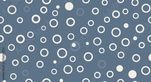 Seamless vector pattern of scattered white and cream polka dots and circles on a muted blue background, creating a simple, abstract, and modern surface design suitable for web or print applications