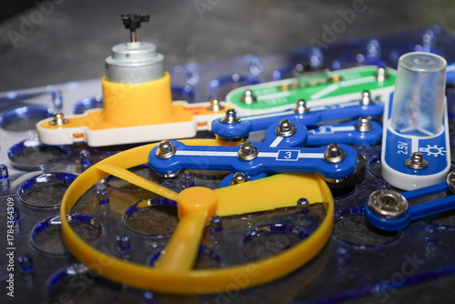 Fotografie An assembled section of an educational electronic construction kit with colored modules, including a yellow propeller, electric motor, and battery compartment, all mounted on a clear plastic base