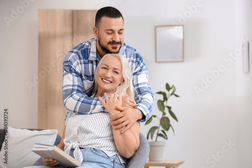 Happy young man hugging his...