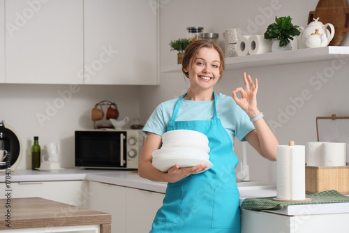 Young woman with dishes and...