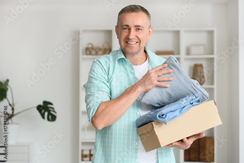 Mature man unpacking box wi...