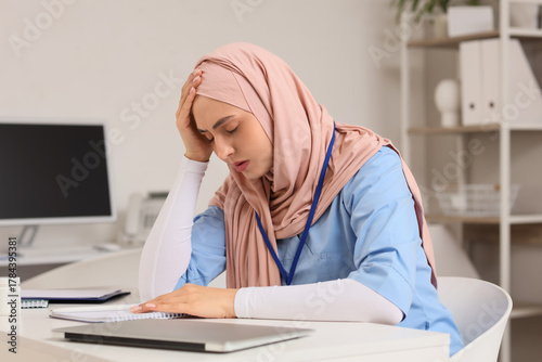 Tired female Muslim doctor ...