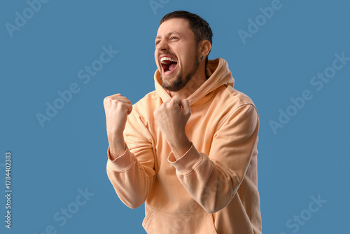 Screaming young man on blue...