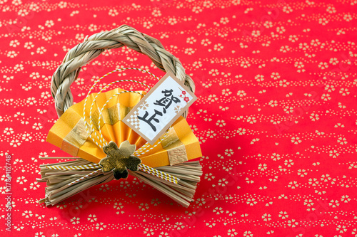 賀正の正月飾り（赤と金の和柄背景）
