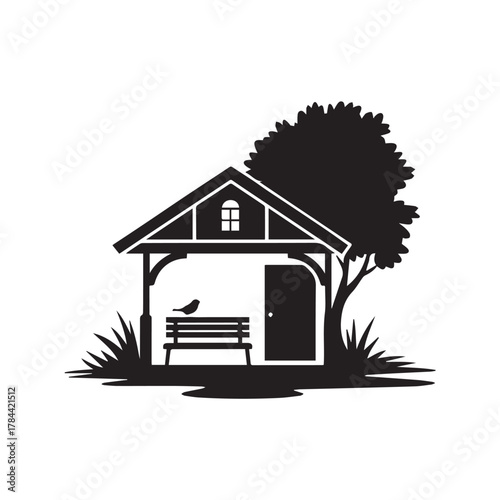 Silhouette of a small wooden shed with a bench and tree
