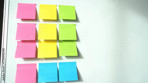 Whiteboard Covered With Colorful Sticky Notes Featuring Rows of Pink Yellow Green and Blue Under Soft Studio Lighting, Perfect For Stock