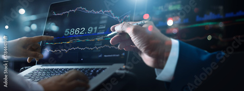Business team working together. Businessman using laptop for analyzing data stock market in monitoring with team pointing on the data growth presented in the chart, Stock chart and investment concept.