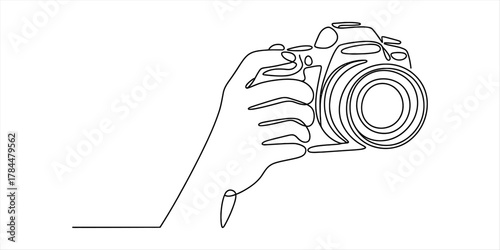 Continuous line drawing of a human hand holding a modern digital slr camera, symbolizing creativity, passion for photography, and artistic expression.