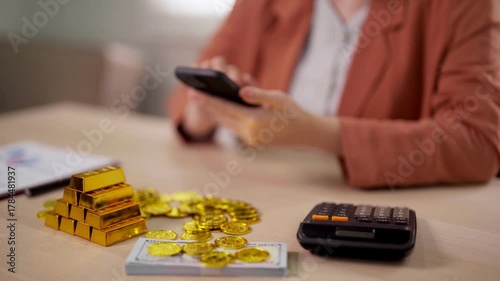Adult hands using smartphone manage gold investment finance wealth online trading calculating money business growth future prosperity desk