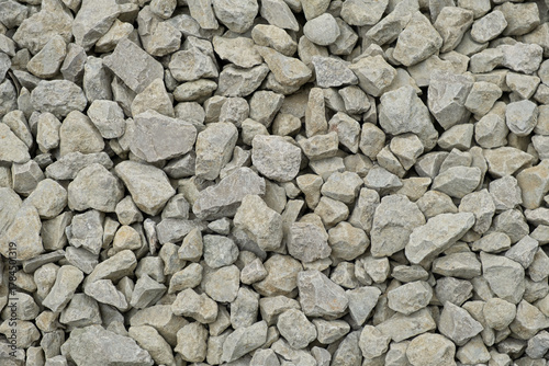 Crushed stone texture close-up. Grey limestone stone for the construction of roads and sidewalks. Abstract background for the design. Solid background with space for text. Construction concept