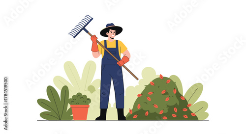 A dedicated gardener in protective gloves and a hat holds a rake, standing next to a pile of raked autumn leaves and various green foliage.