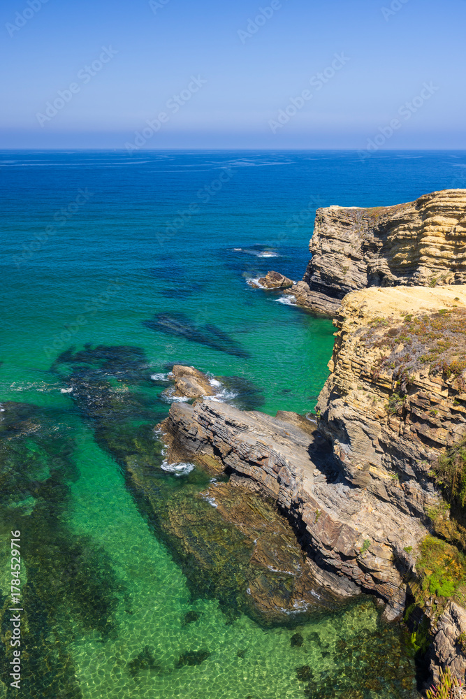 Fototapeta premium Atlantic ocean washing rugged cliffs Odemira Portugal