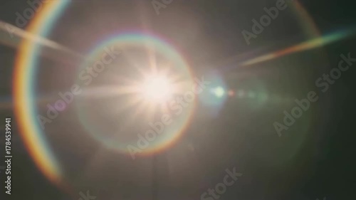 Lens flare rainbow light leaks on dark background with smooth organic motion and vintage film look, seamless looping effect.