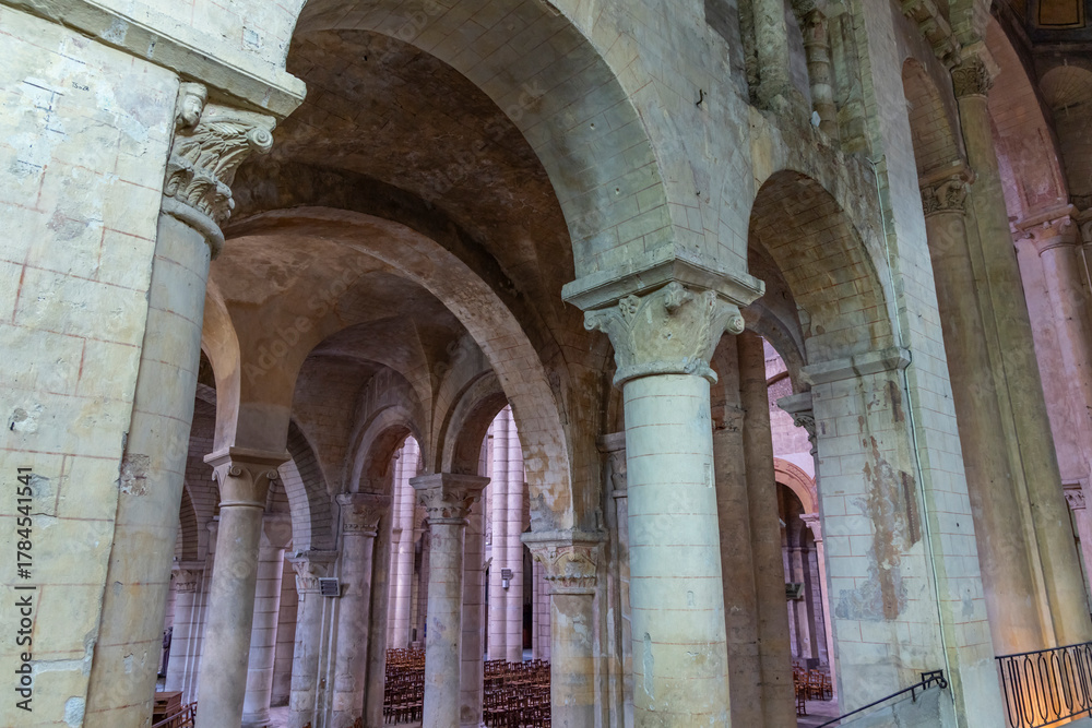 Obraz premium Stone columns and arches forming the interior nave of ancient church