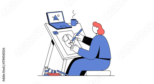 Artist working on digital art with laptop and coffee.