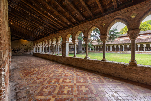 Behang Moissac Abbey cloister showing Romanesque architecture and tranquil courtyard