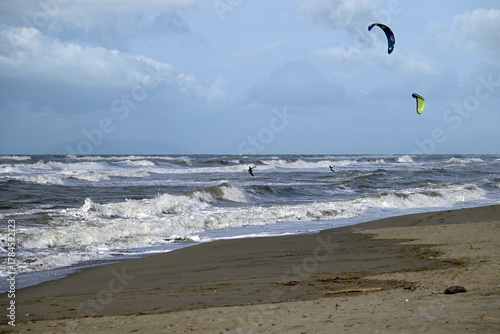 Kitesurfing at italian beach. Some kitesurfers at Torre del Lago beach, tuscany, italy. Some are junping out of the water. Mediterraenean Sea.