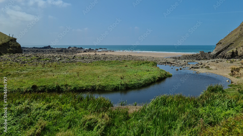 Obraz premium Stream and Shoreline: Coastal Confluence near Bude