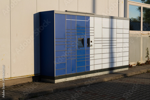 Automated parcel locker outdoors in sunlight
