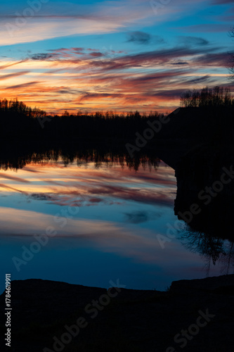 Beautiful sunset and trees reflecting in calm water