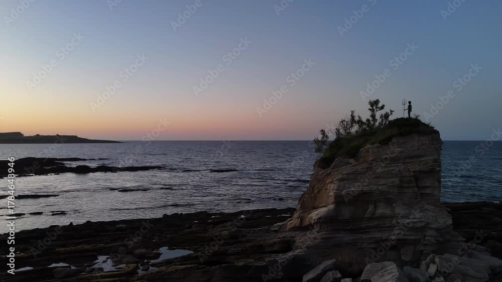 Rocher de Poséidon au lever du soleil. Plage de Santander en Espagne, prise de vue au drone tournant autour. 