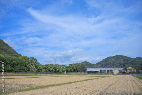 稲刈り跡の農地と秋晴れの空と高速道路