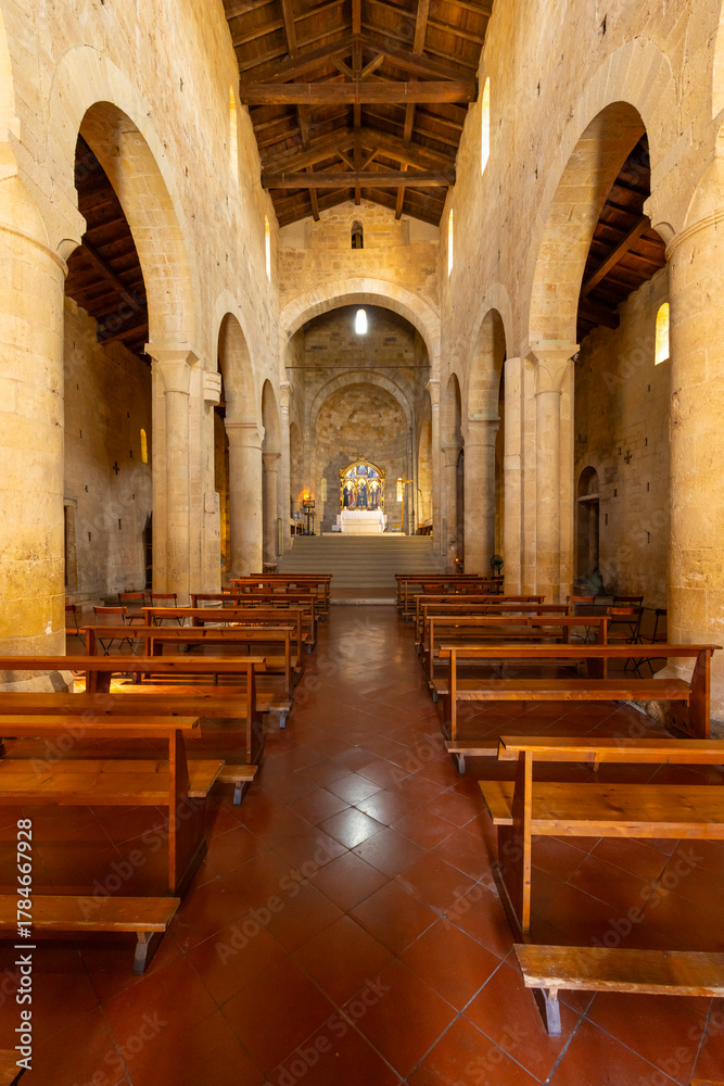 Obraz premium Church interior with wooden pews and stone arches in Monteriggioni