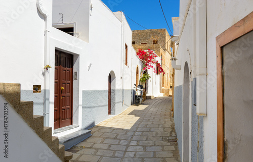 Fototapeta Naklejka Na Ścianę i Meble -  Cobblestone street with white houses on Rhodes island. Lindos village, Dodecanese, Greece.