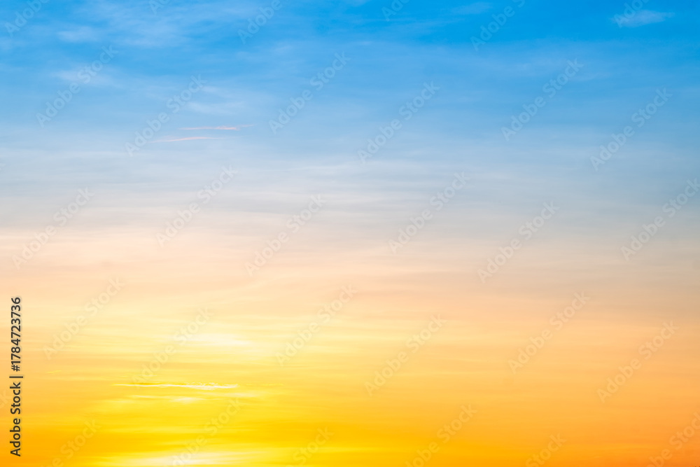 Obraz premium Sunset or sunrise sky with a vibrant gradient of orange, gold, and soft blue. Clear atmosphere with wispy clouds. Peaceful, natural light background. hope, freedom, new day and inspirational Concepts