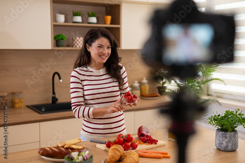 Woman food blogger vlogging cooking healthy meal at home kitchen