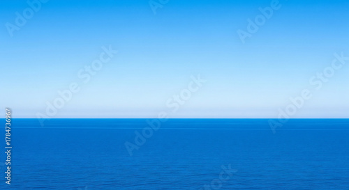 Fototapeta Naklejka Na Ścianę i Meble -  Vast expanse of the deep blue sea meeting the clear blue sky above it