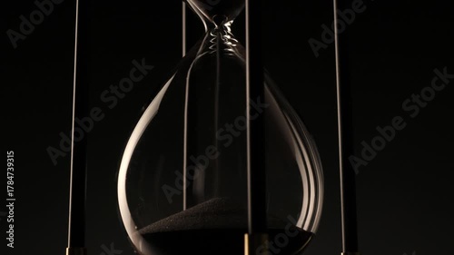 conceptual image of a rotating hourglass in low light, symbolizing eternity, change, and the fragile beauty of every second.