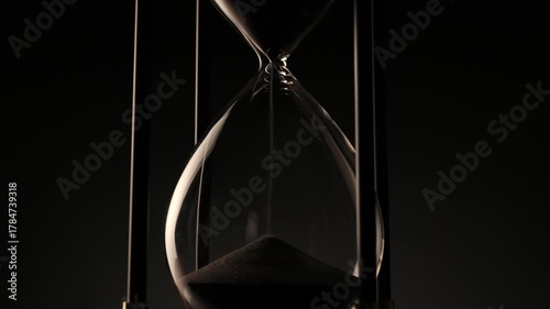 elegant hourglass with sand in motion, a poetic symbol of patience, transition, and the irreversible passing of time