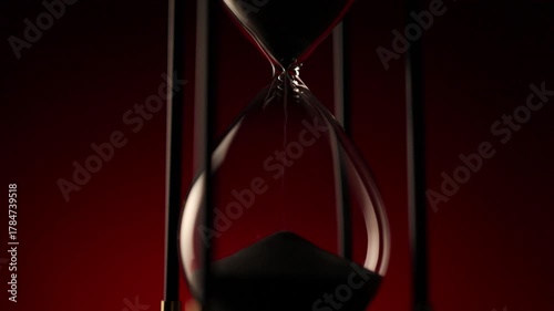 elegant hourglass with sand in motion, a symbol of  the irreversible passing of time