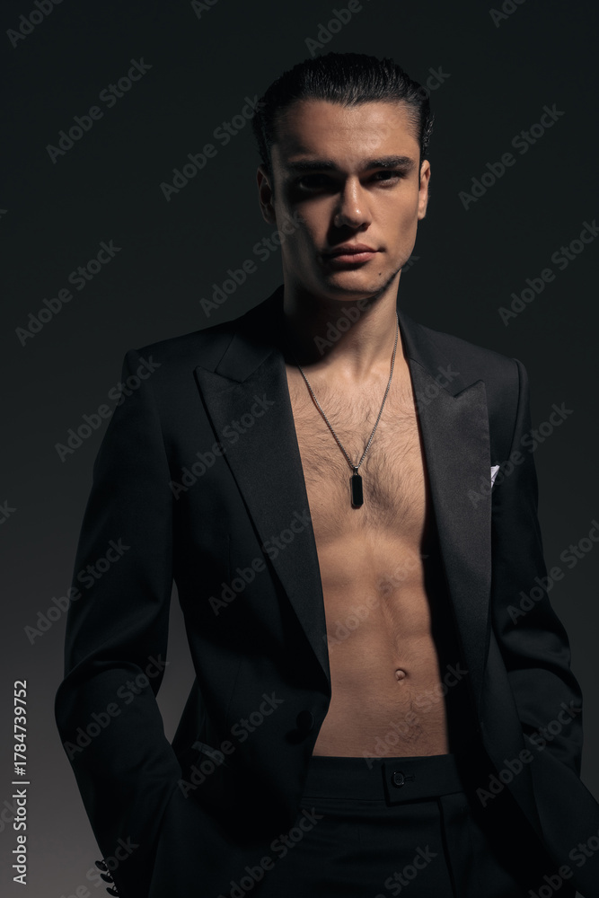 Fototapeta premium sexy shirtless man in black tuxedo holding hands in pockets and looking forward