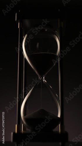 elegant hourglass spinning slowly in the dark, representing balance, patience, and the eternal rhythm of time�s continuous cycle